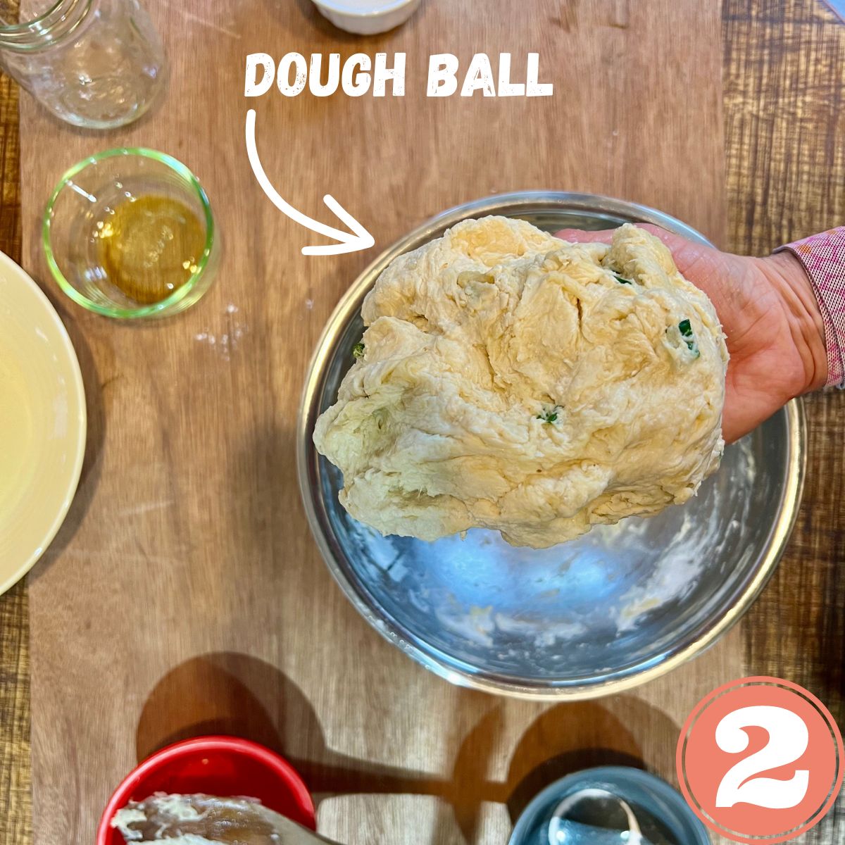 a hand holding a vegan dough ball