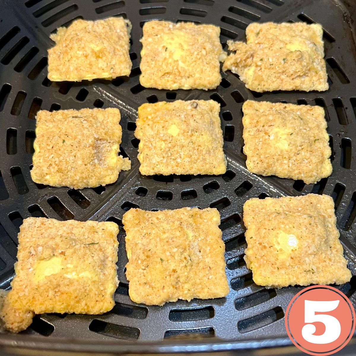 Nine toasted raviolis in an air fryer basket