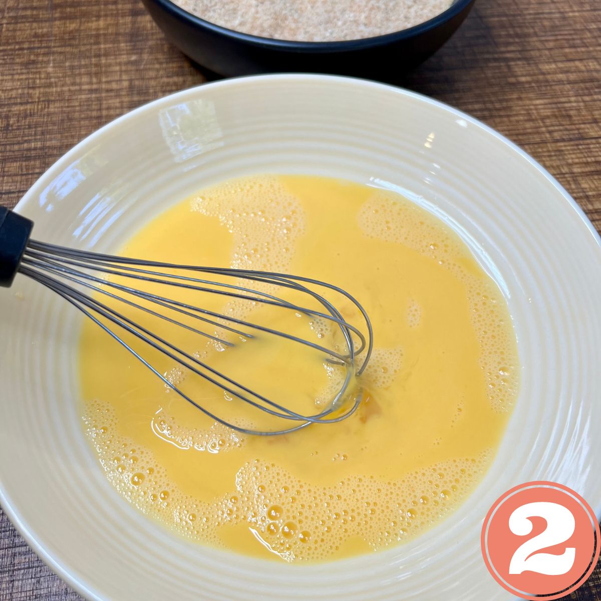 Whisking egg batter in a white bowl