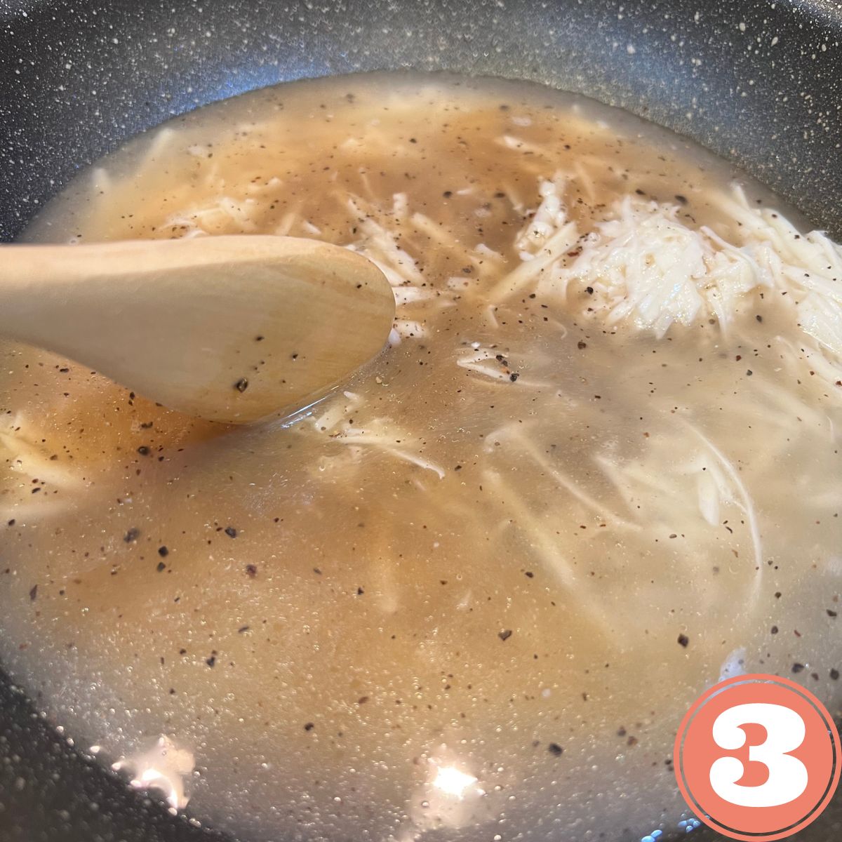 WW Cacio E Pepe sauce in a pan being stirred by a wooden spoon