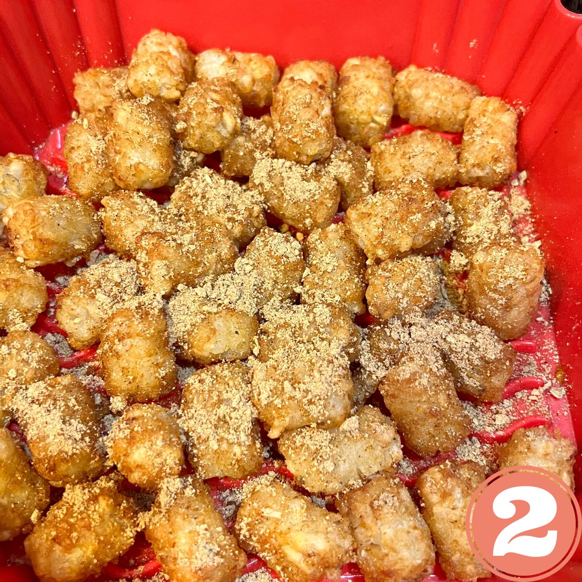 Frozen tater tots in a red silicone air fryer liner basket