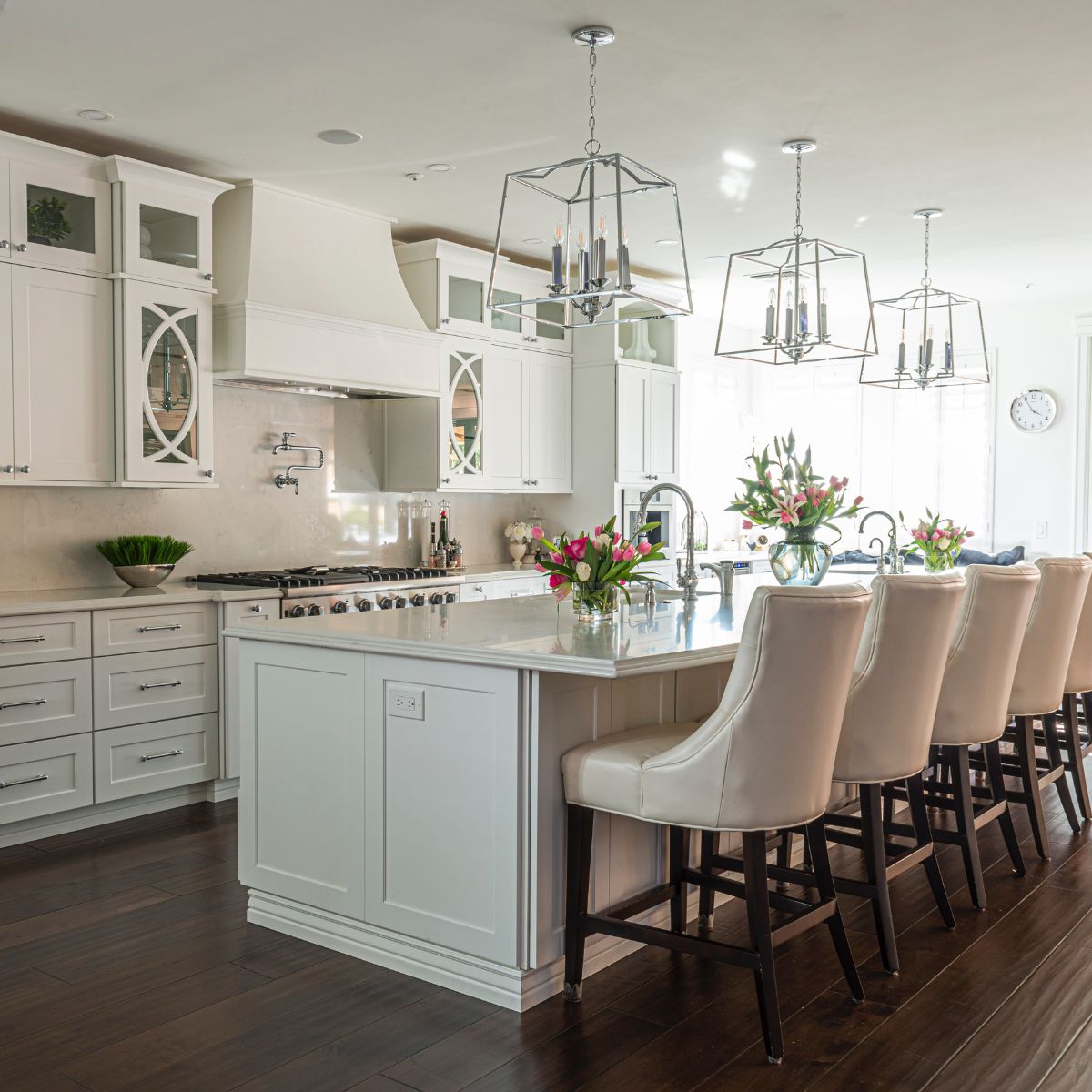 A white kitchen with an island and dining chairs