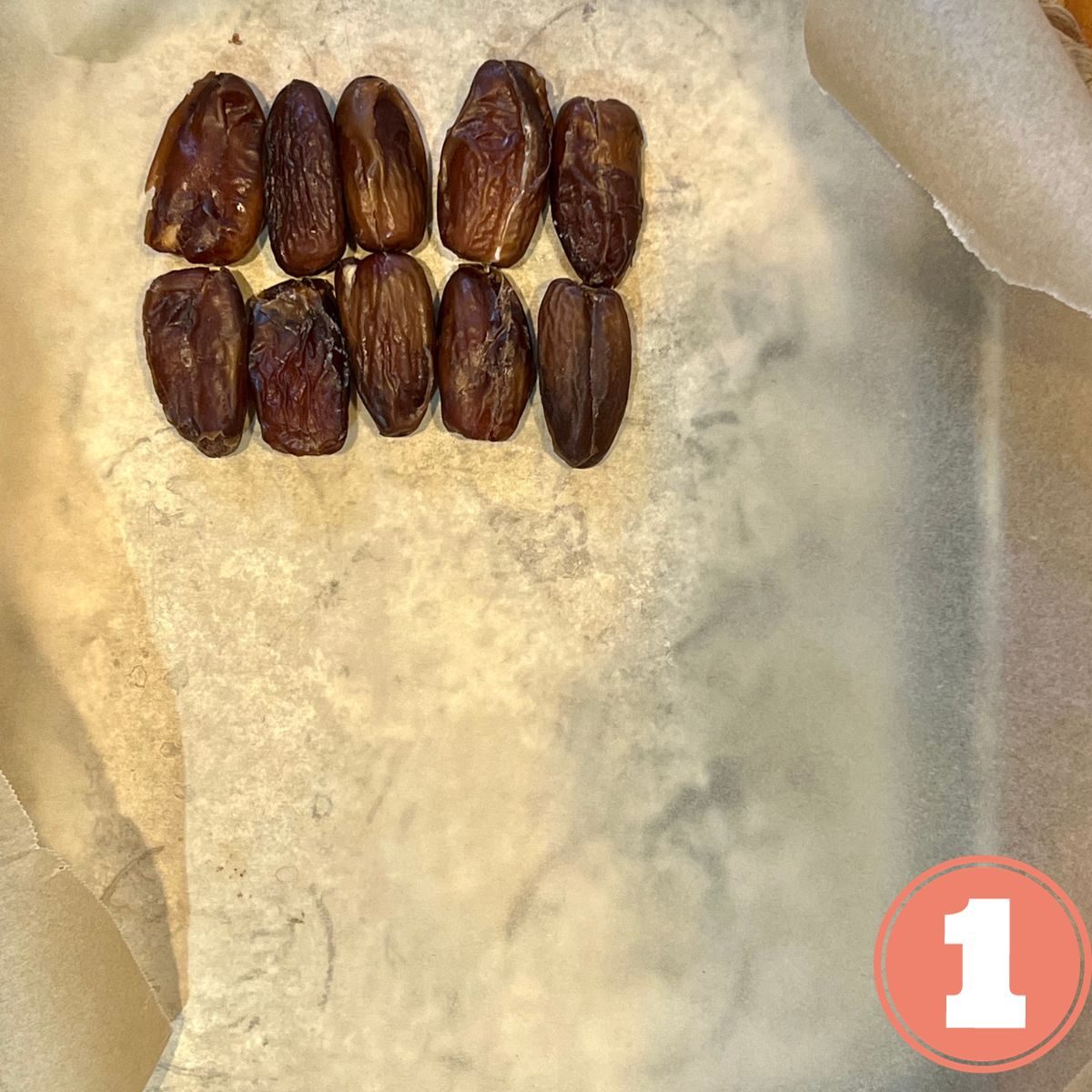 Pitted dates on a sheet pan lined with parchment paper