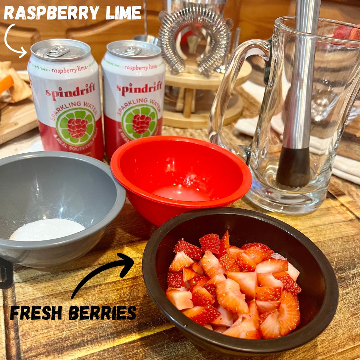 Mocktail ingredients 2 can of raspberry lime sparkling water a bowl of fresh berries lime juice sugar and a muddler