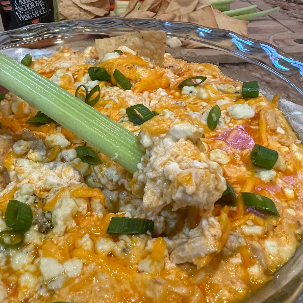 A celery stick being dipped in buffalo chicken dip