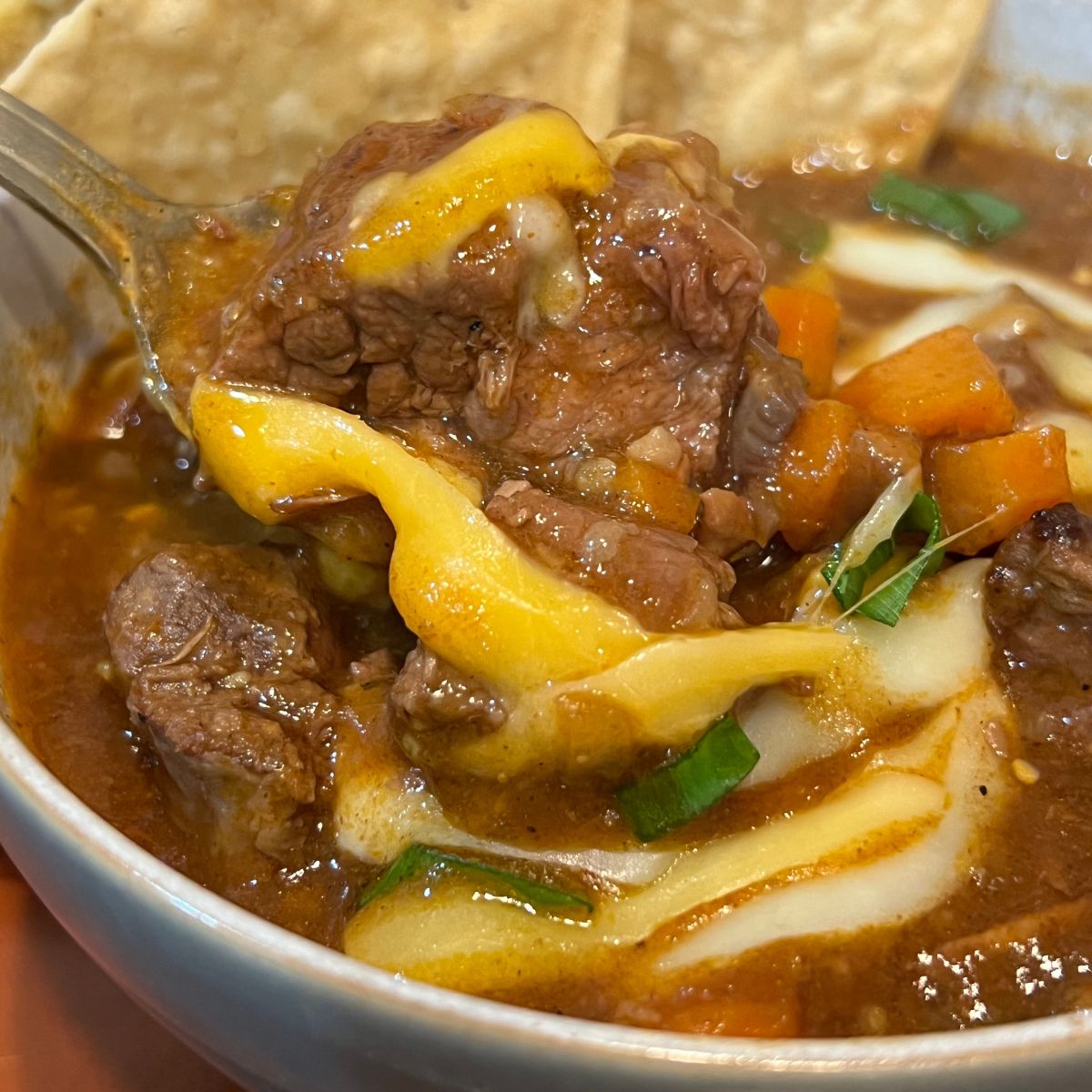 Keto chili con carne in a white bowl with Tostito chips