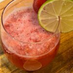 Double Berry Mocktail Spritzer in a wine glass with a lime slice