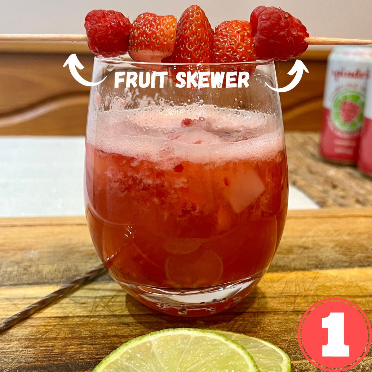 a glass with fresh berry mocktail spritzer with a fruit skewer on top