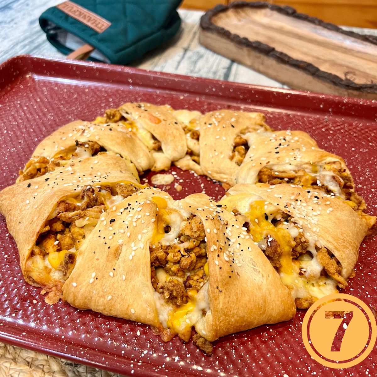 Oven baked crescent roll taco ring on a red sheet pan