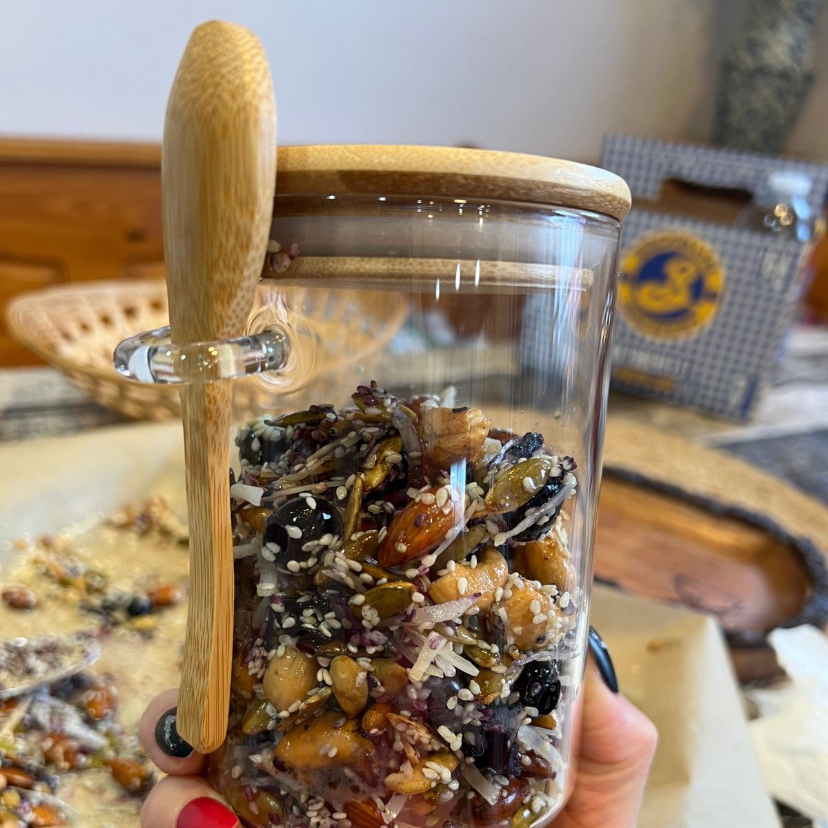 Grainless Granola in a glass container with a wooden spoon