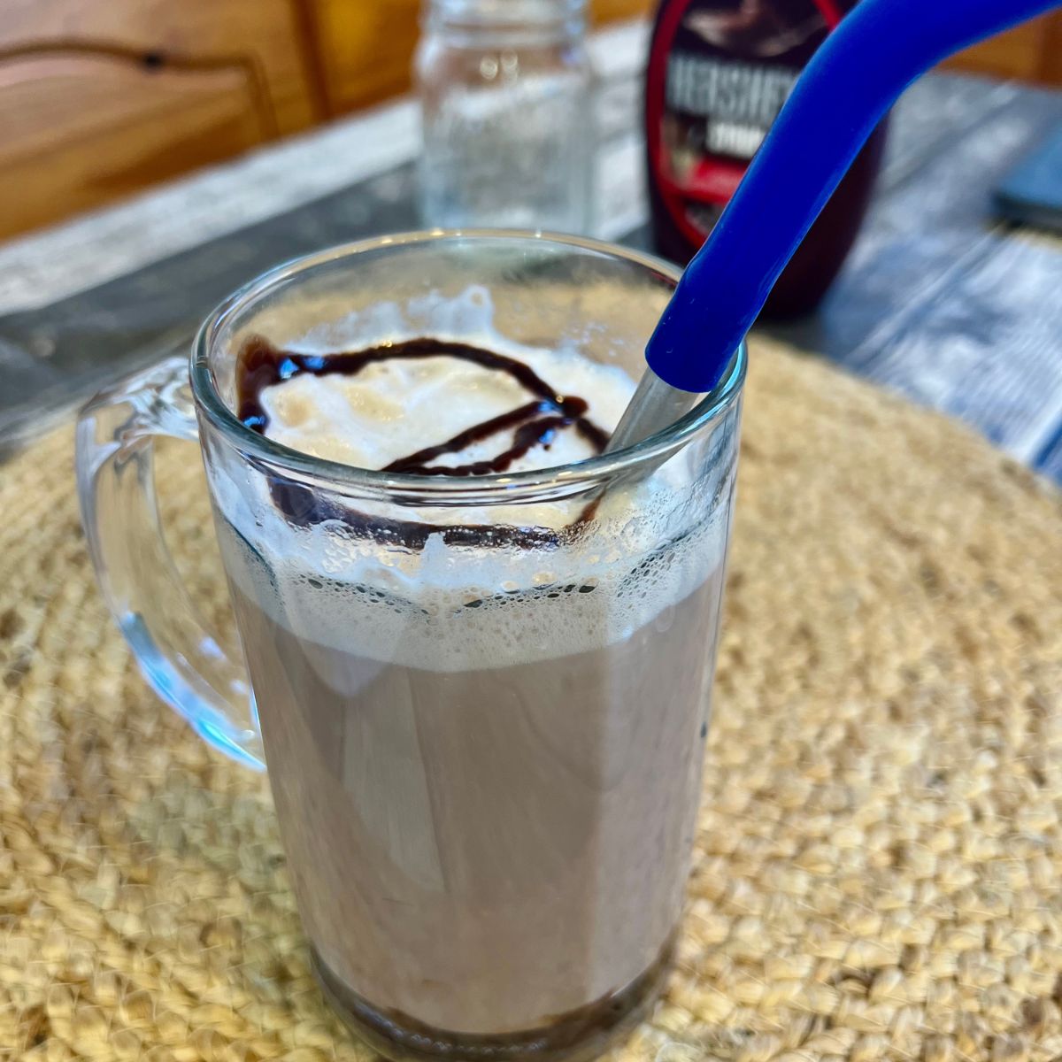 Homemade chocolate egg cream in a glass beer mug on a wooden table