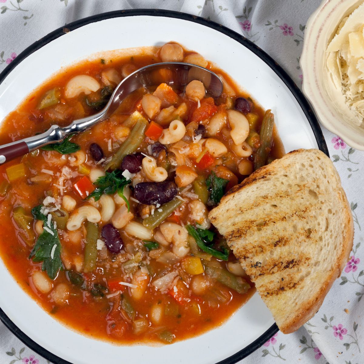 A bowl of minestrone soup with toasted bread slice