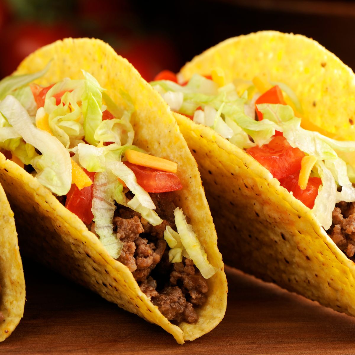 Two hard shell tacos with chop meat and lettuce and tomatoes