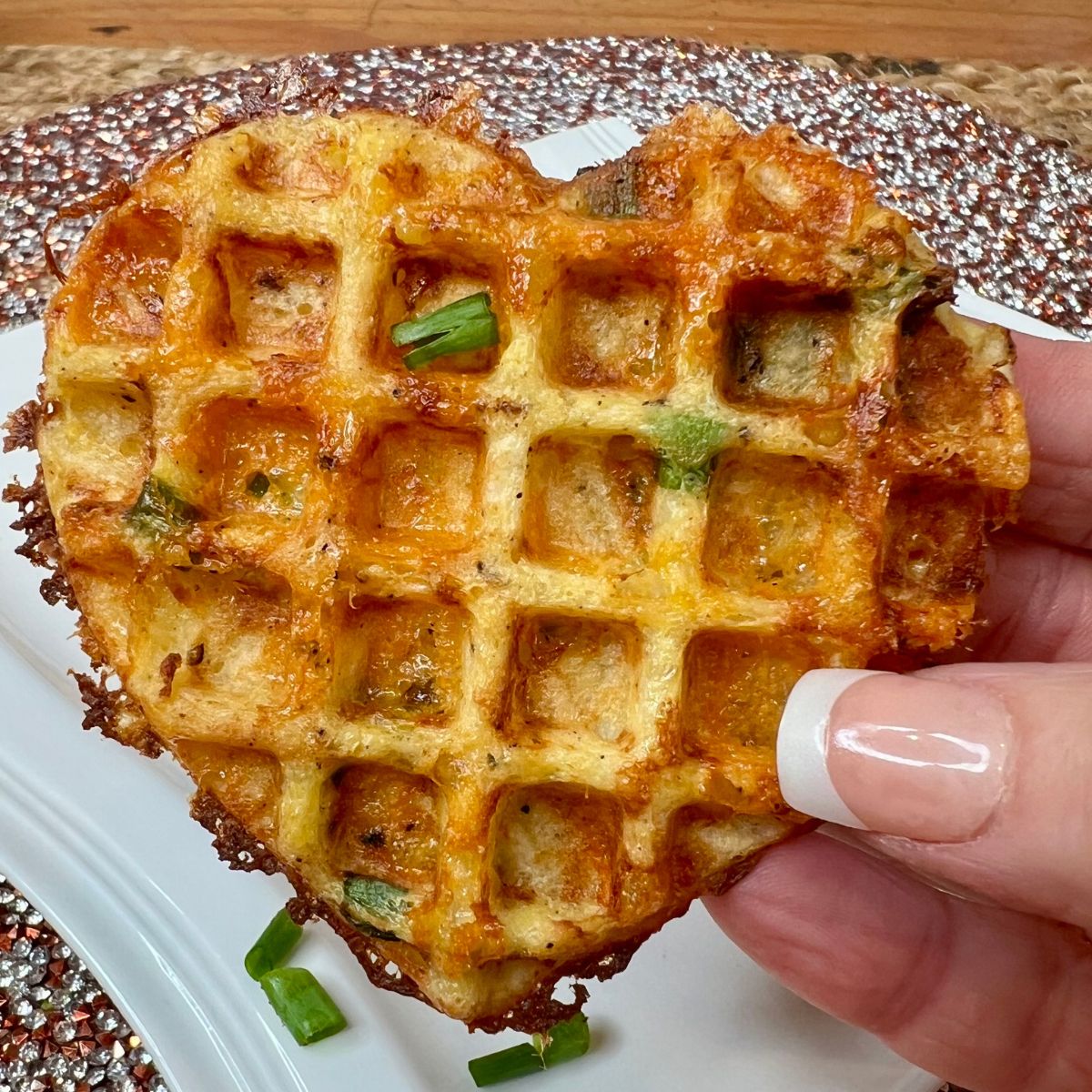 A hand holding a Weight Watchers heart shed mini waffle