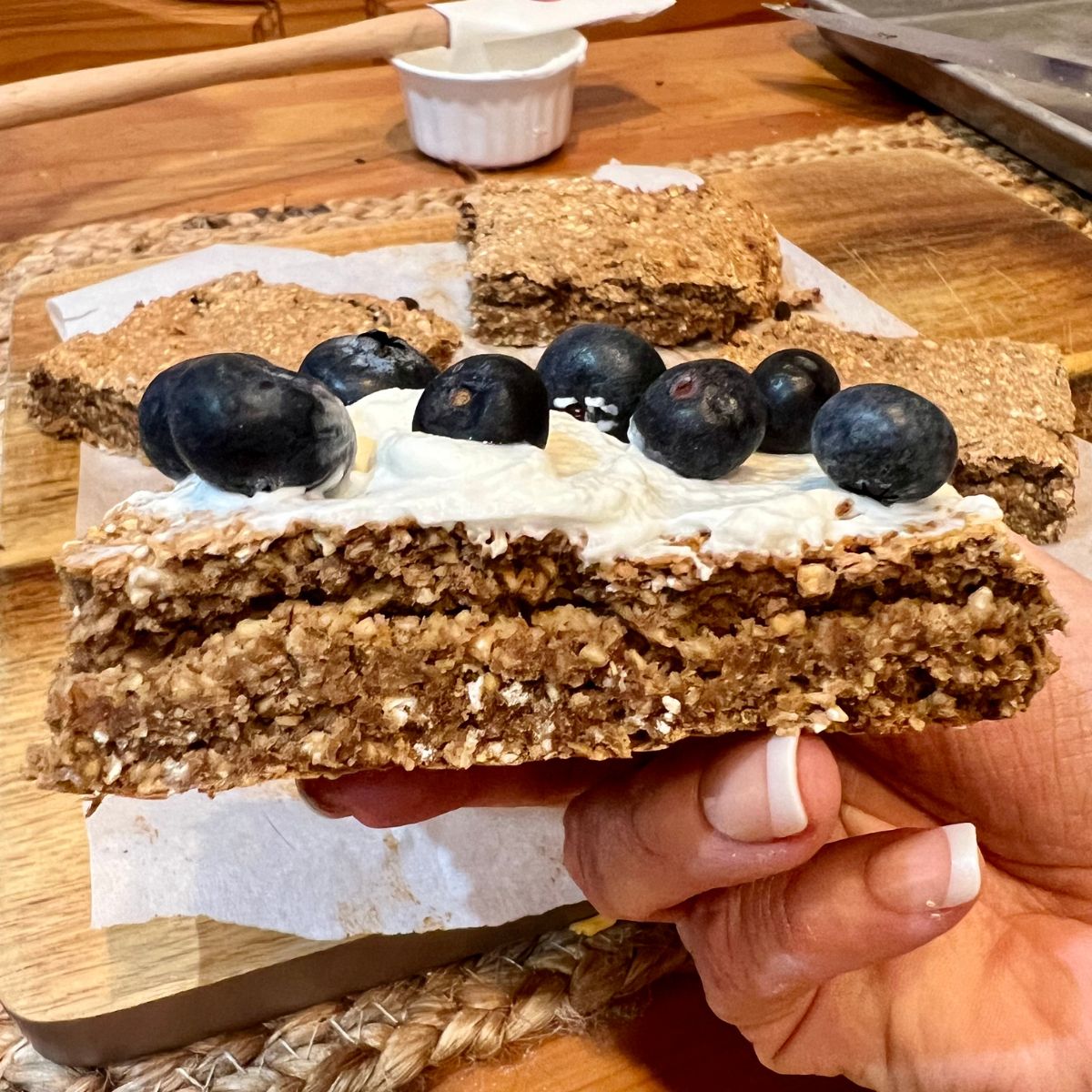 A hand holding an oatmeal breakfast bar