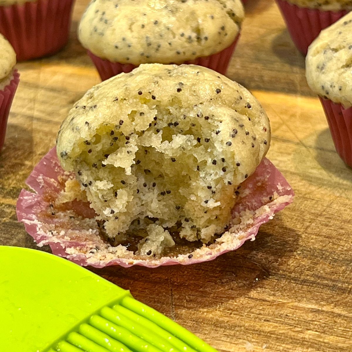 A glazed lemon poppyseed muffin with a bite taken out of it