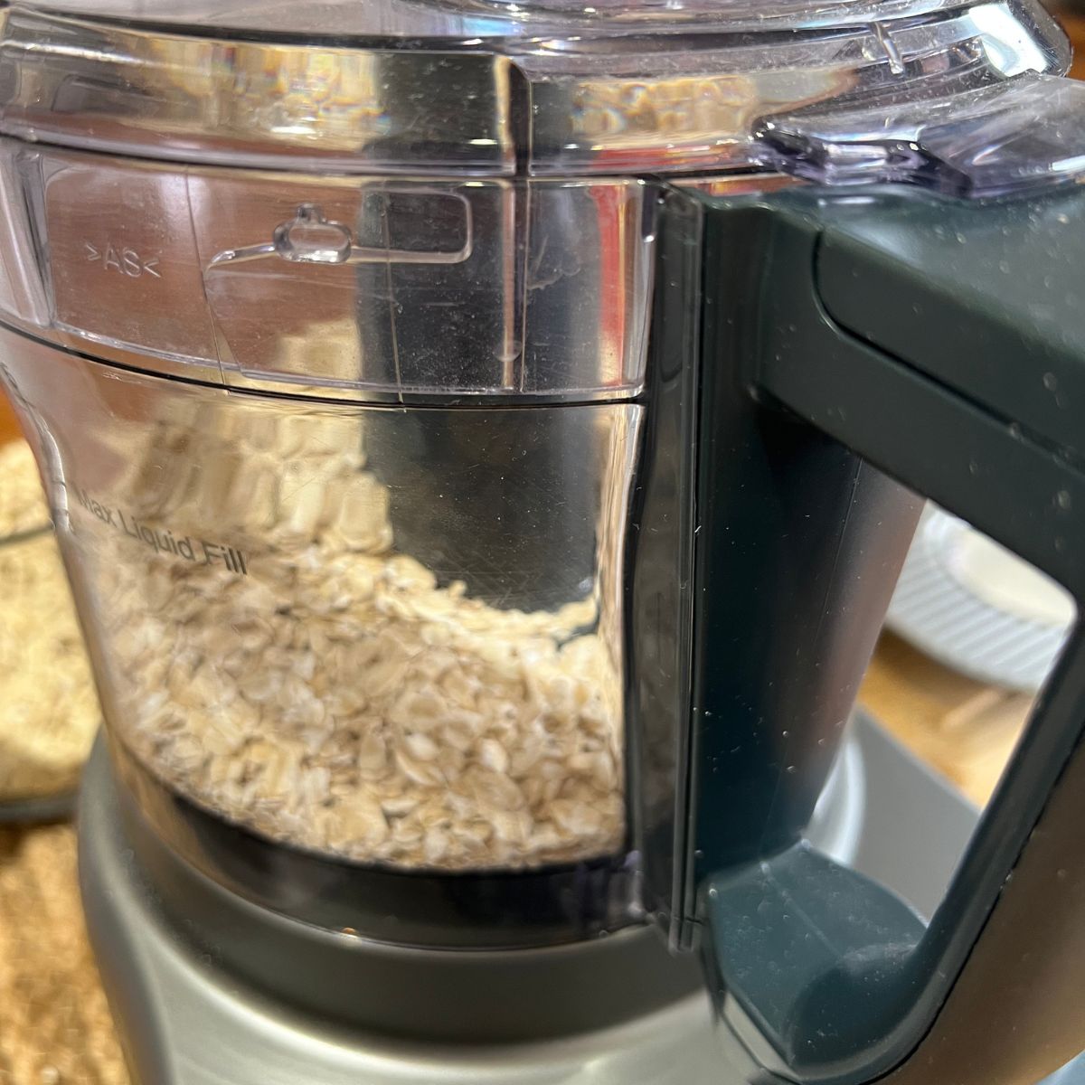 A food processor filled with rolled oats