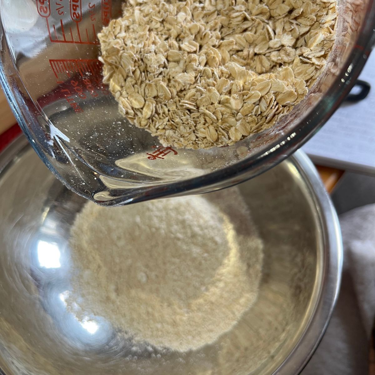 rolled oats being poured into a bowl of powdered oats