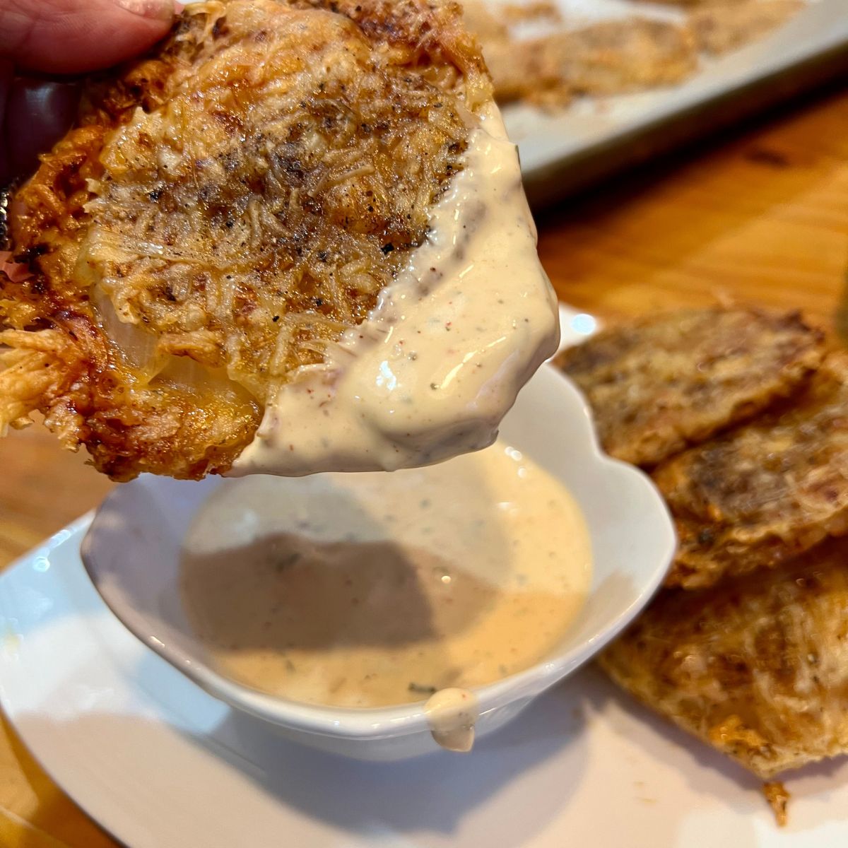 Dipping a baked onion chip in chipotle dressing