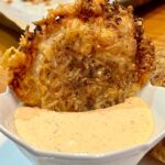 Parmesan Onion Ring chip in a bowl of chipotle dip