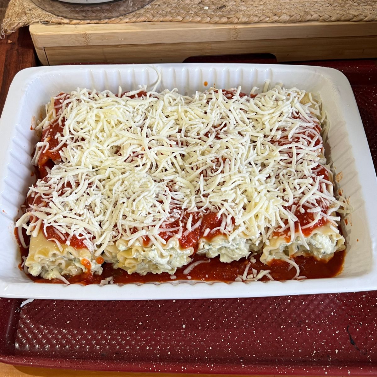 Mozzarella covered lasagna rollups in a casserole dish