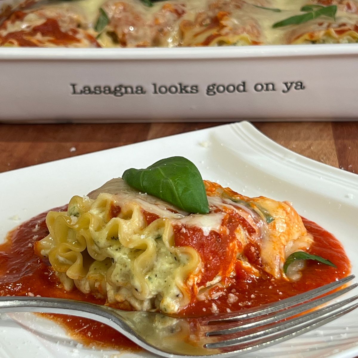 High Protein cottage cheese lasagna roll-up on a white plate with a fork