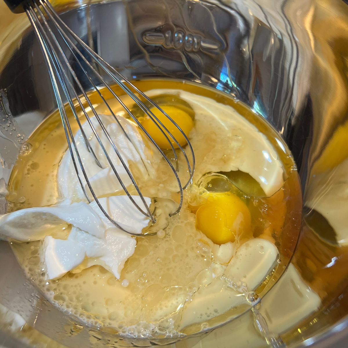 Gluten Free Blueberry Muffin wet ingredients in a bowl with a whisk