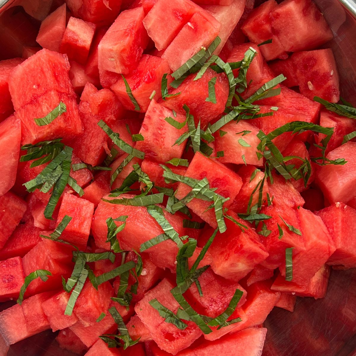 Fresh chopped mint on cubed watermelon for a watermelon with feta cheese salad