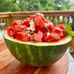 Watermelon feta mint salad in a watermelon bowl on a table