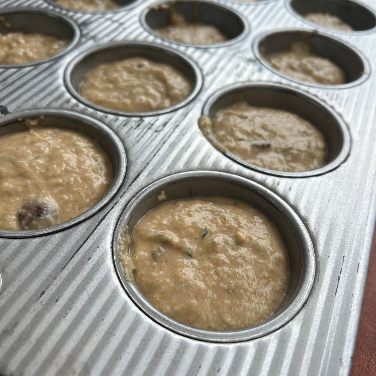 Chocolate chip banana zucchini muffin batter in a muffin tin