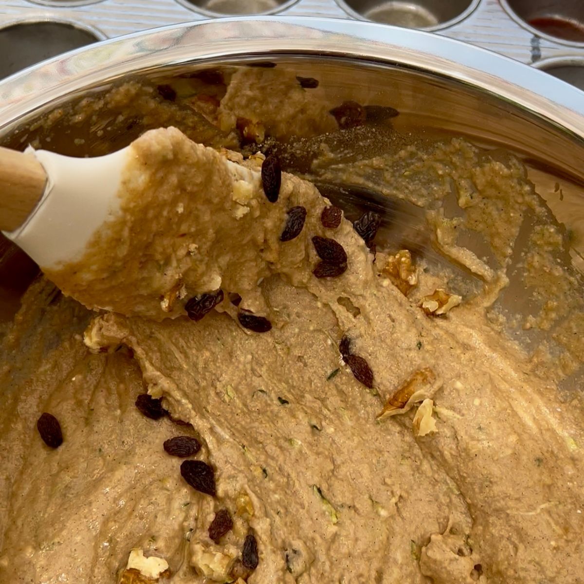 Raisins and walnuts in healthy zucchini muffin batter