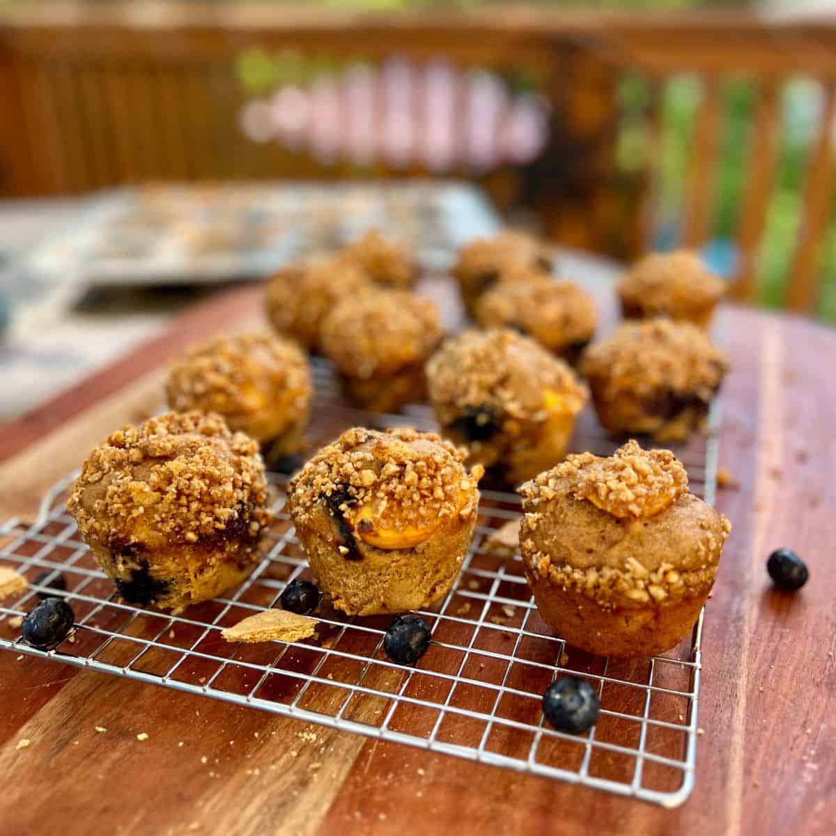 Healthy peach blueberry muffins cooling on a wire rack