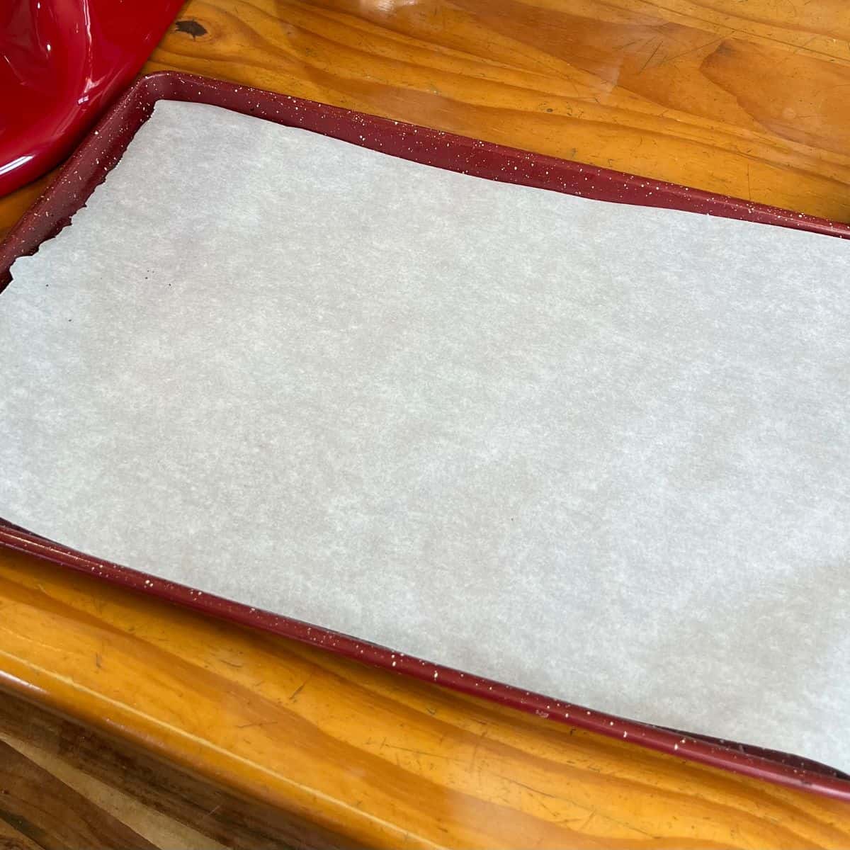 A sheet pan lined with parchment paper to bake marshmallow chocolate chip cookies