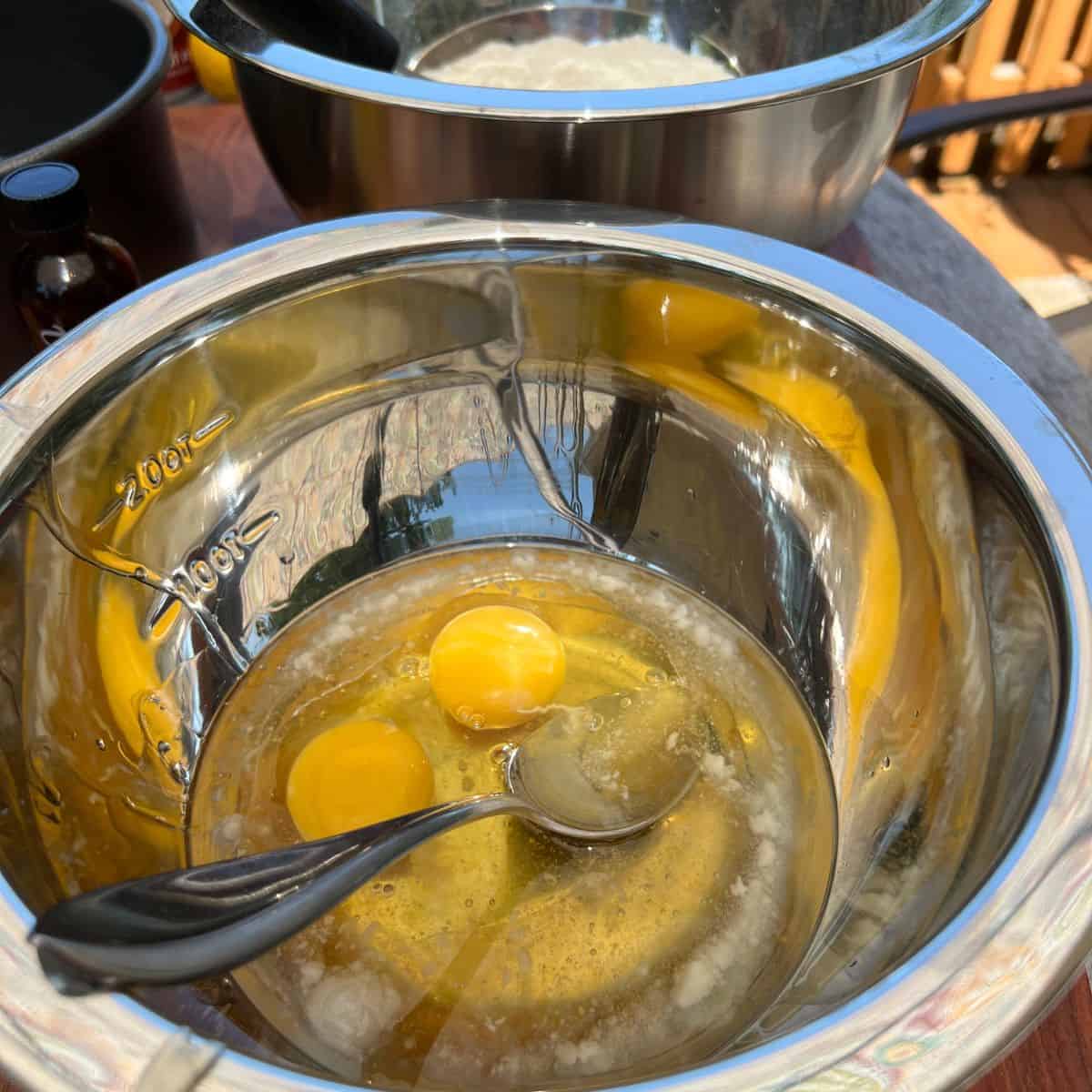 Eggs and coconut oil in a bowl for a lemon-coconut cake recipe