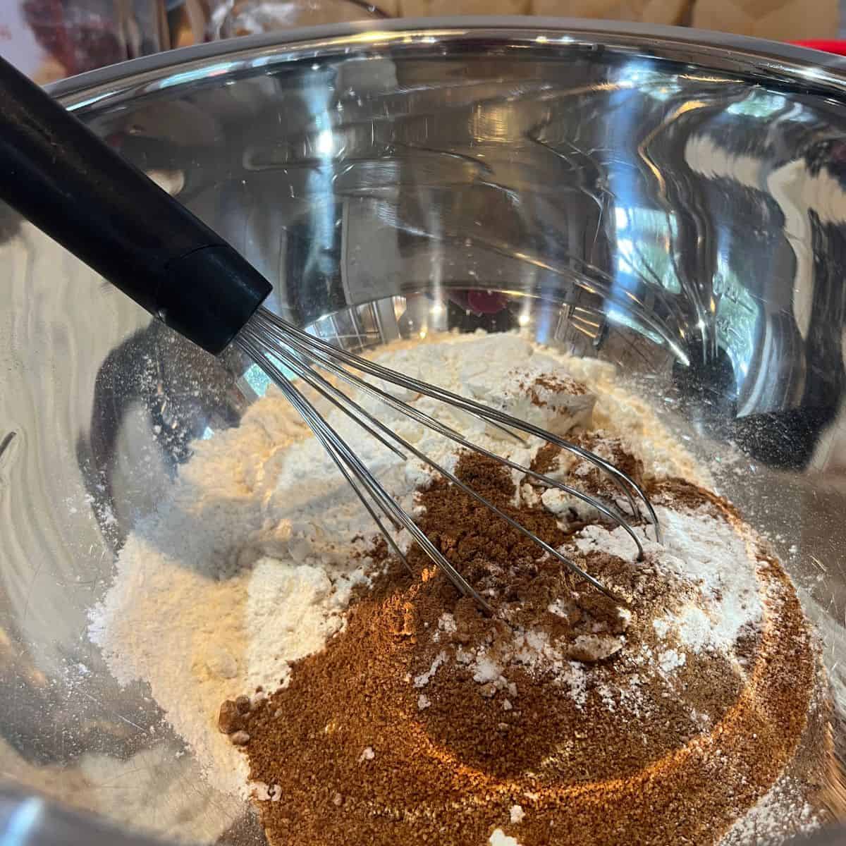 Whisking dry ingredients for a pear crumble muffin recipe