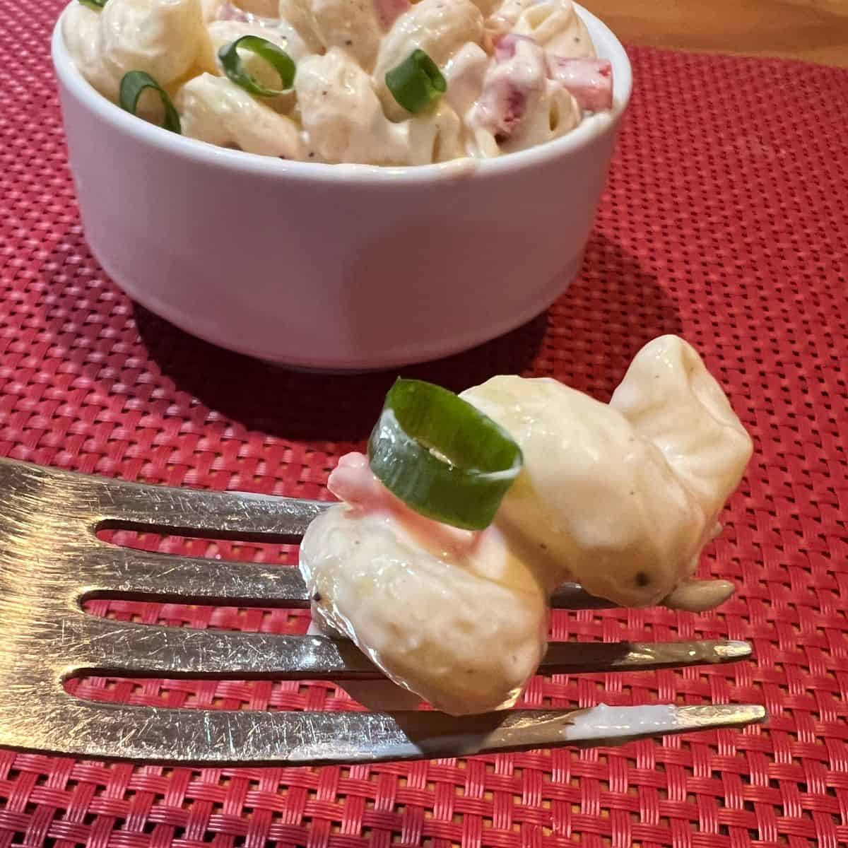 A healthy macaroni salad noodle on a fork