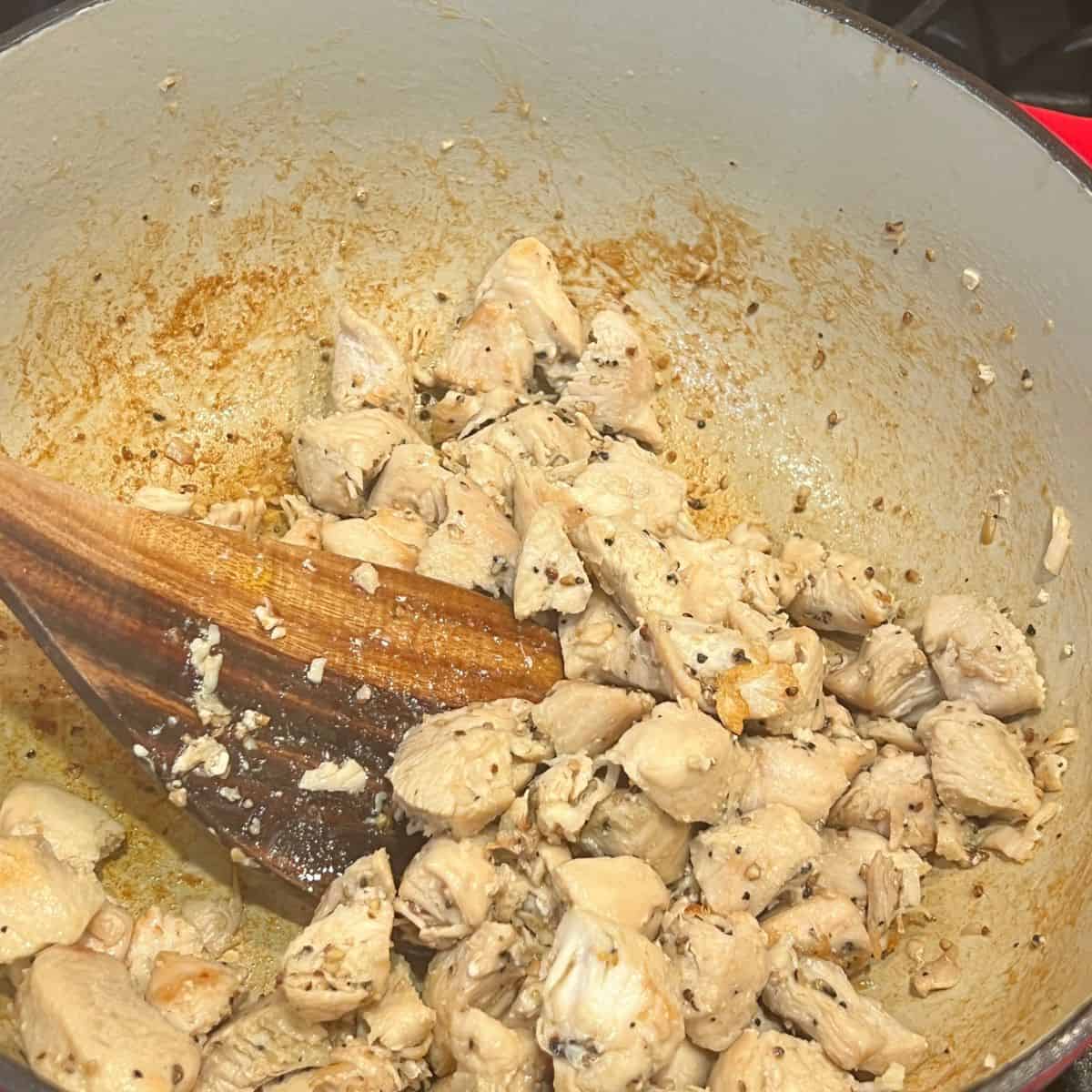 Chicken pieces cooking in a stockpot for healthy Marry Me Chicken recipe