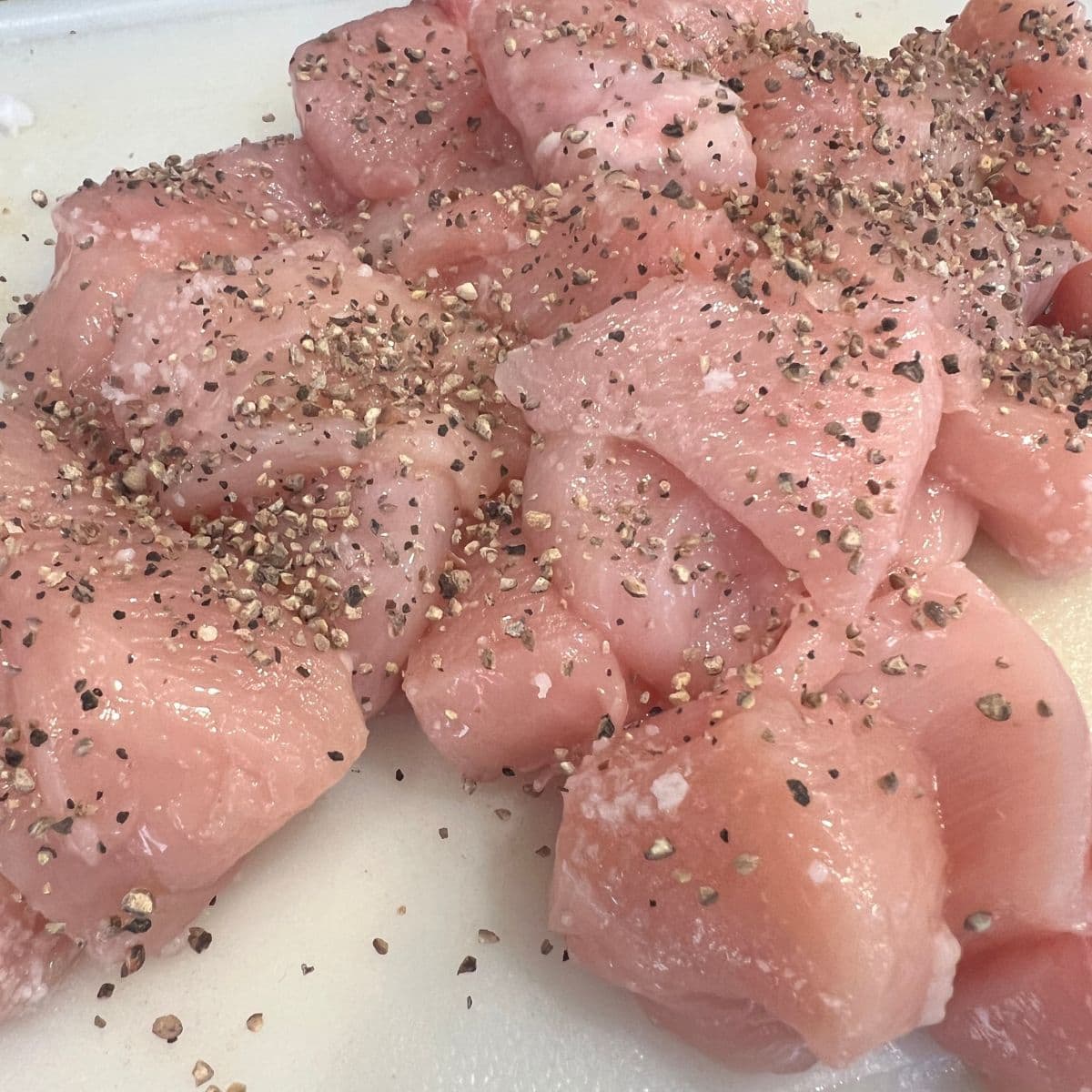 Diced chicken chunks covered in salt and pepper for the Marry Me chicken recipe