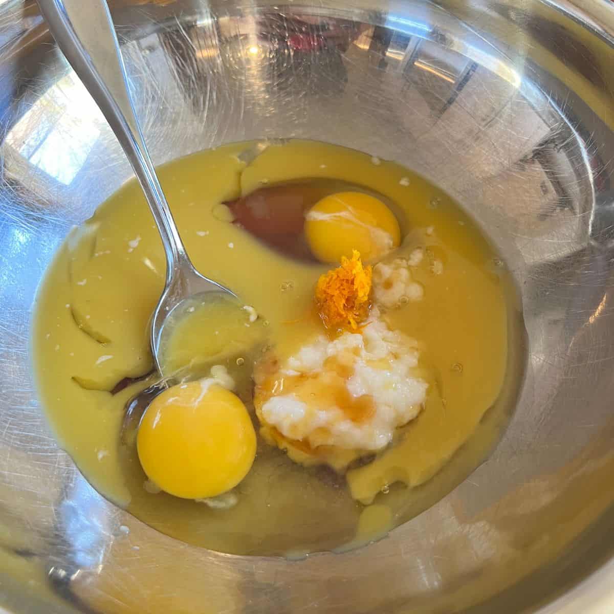 Honey egg coconut oil in a mixing bowl for a healthy cranberry orange muffin recipe