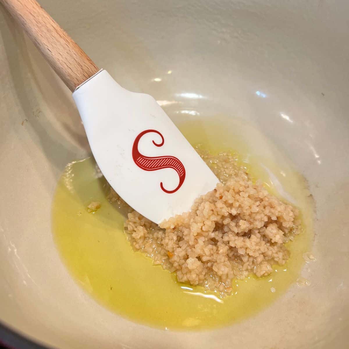 Garlic and olive oil in a Dutch Oven for one pot garlic pasta