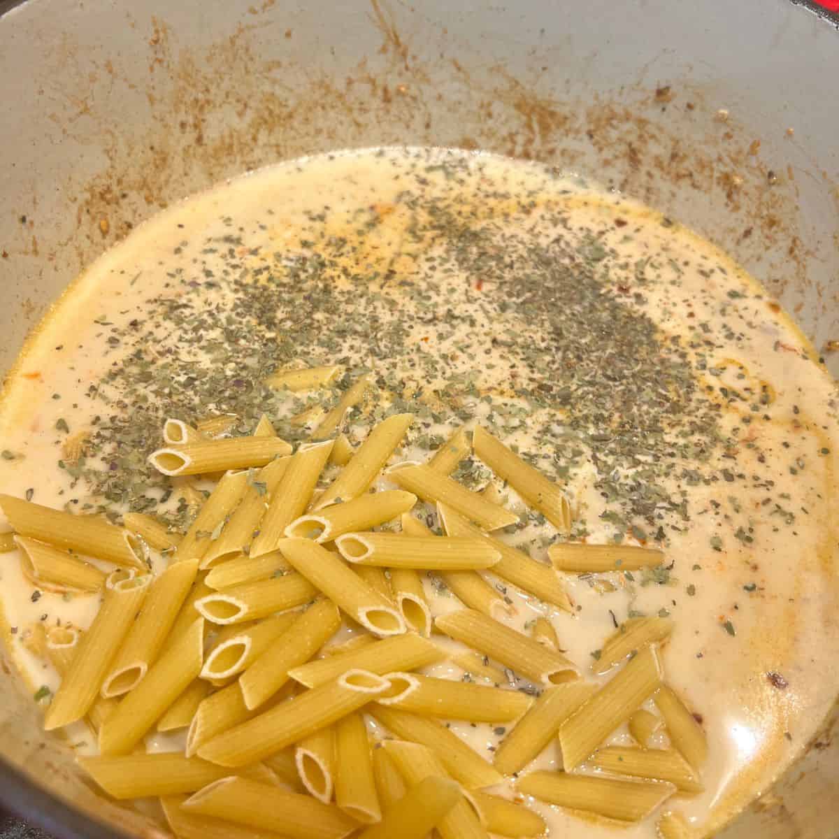 Penne pasta in a dutch oven cooking