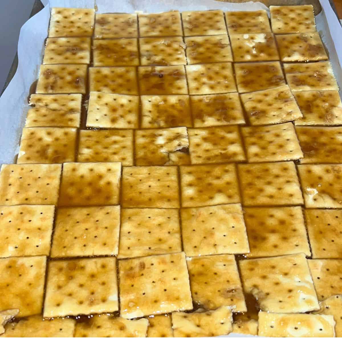 Toffee covered saltine crackers on a sheet pan