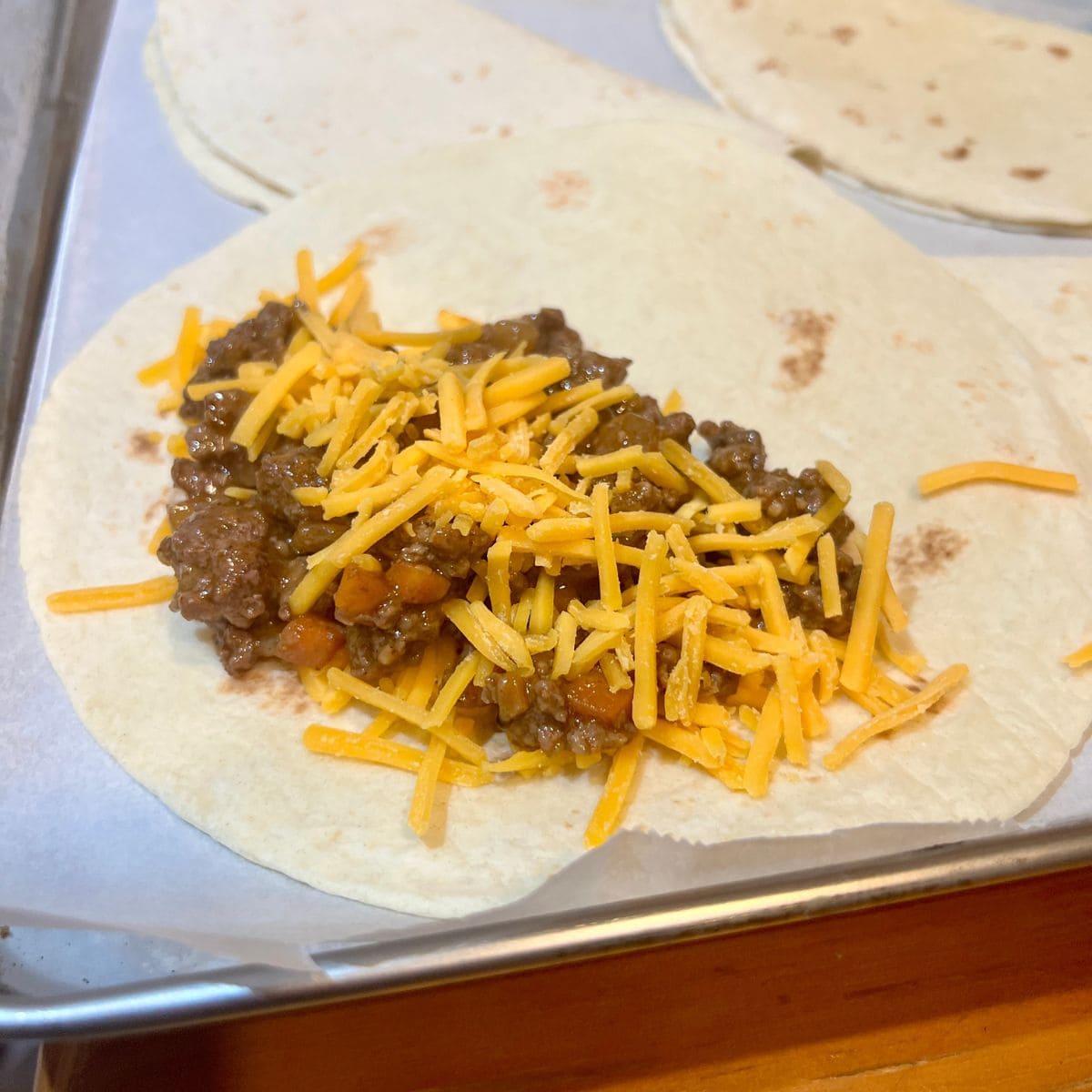 Flour tortilla filled with beef and shredded cheddar cheese