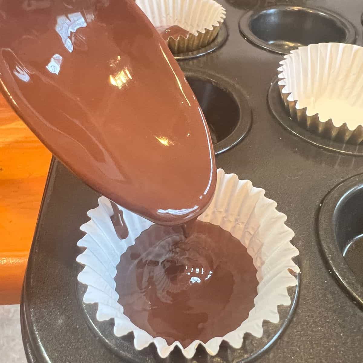 Spooning melted chocolate into a paper liner