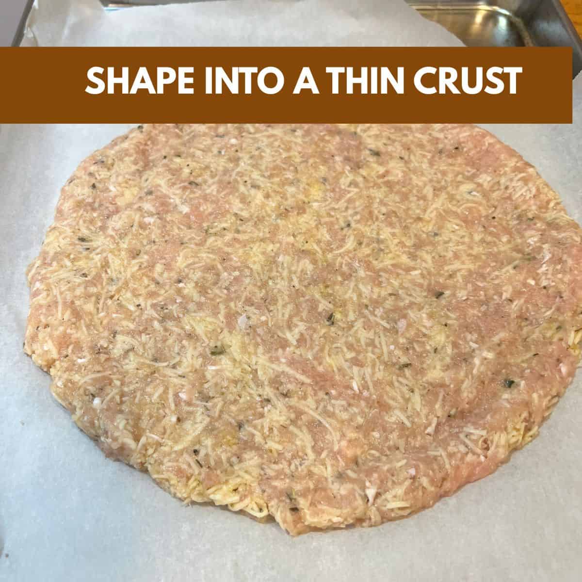 Ground chicken mixture pressed into a thin pizza crust shape on a baking sheet for keto chicken crust pizza