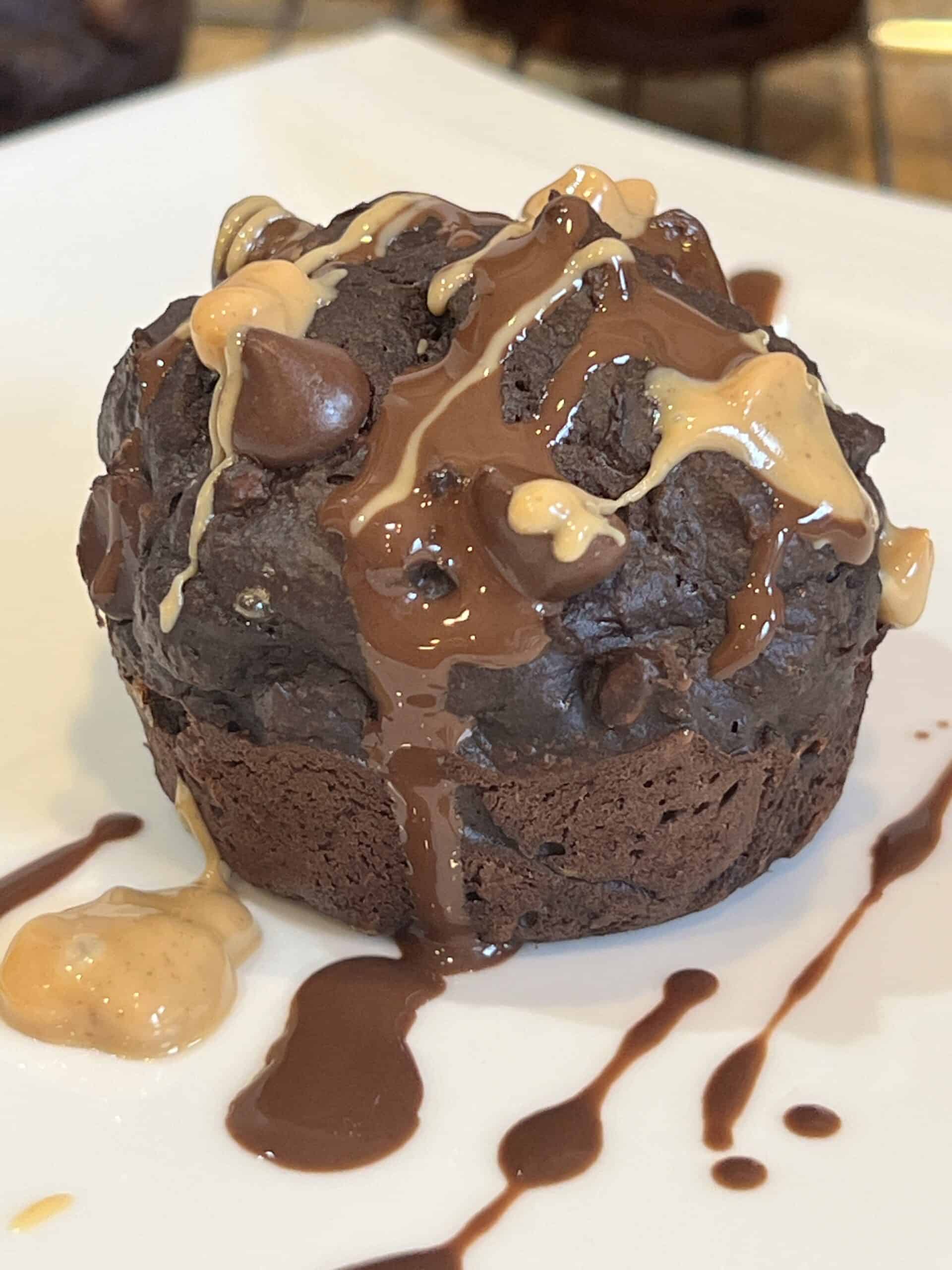 Close-up of chocolate peanut butter muffin drizzled with melted peanut butter and chocolate