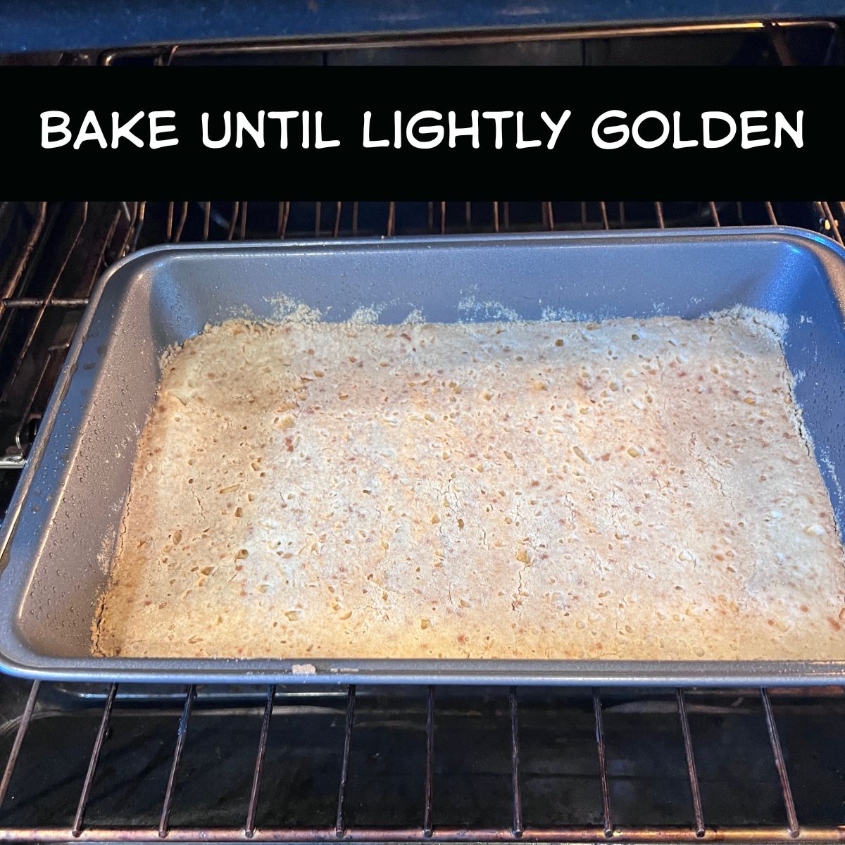 Lemon bar crust baking in a 13x9 pan in the oven until lightly golden