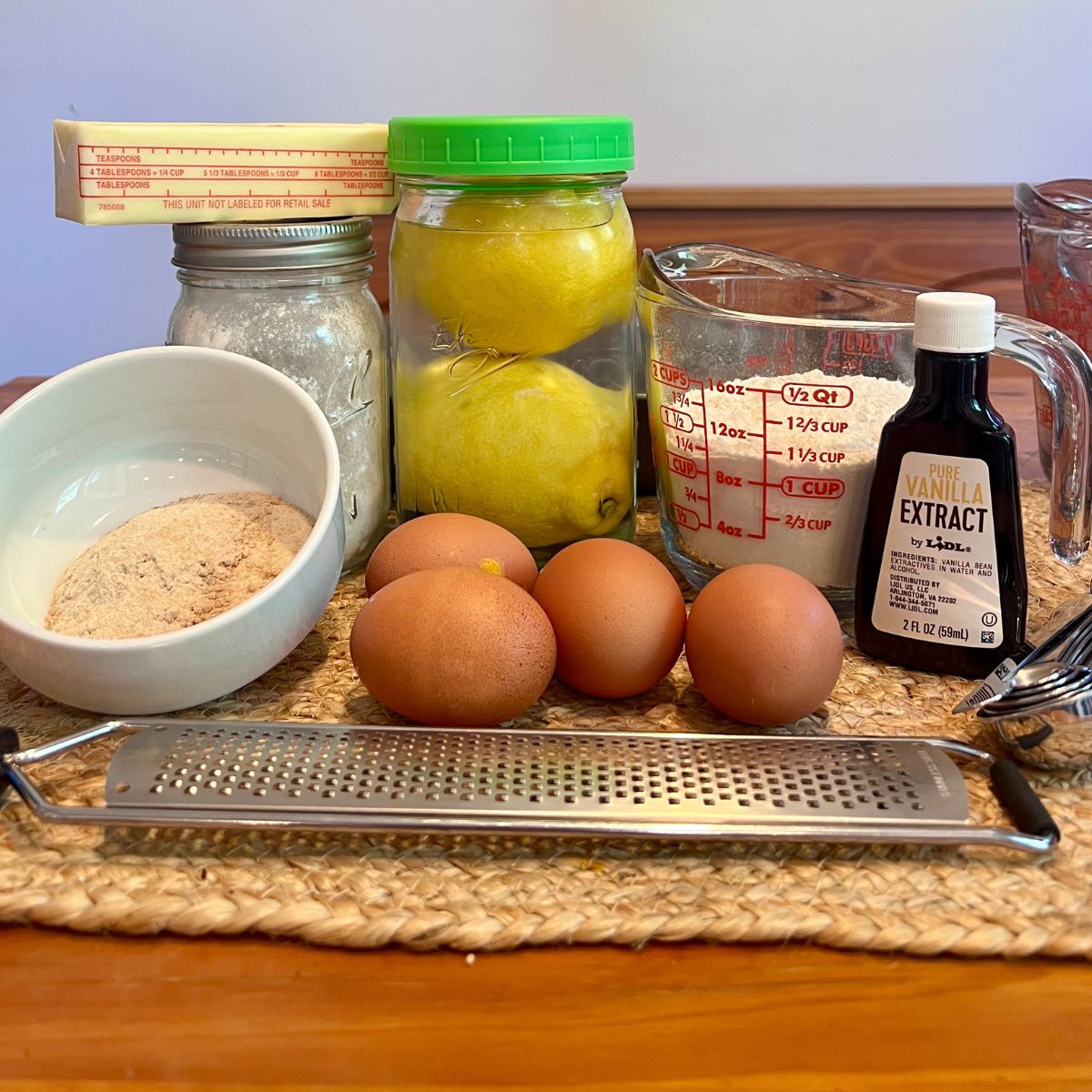 ngredients for healthy lemon bars including flour, eggs, butter, lemon juice, and lemon zest on a table