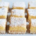 Healthy lemon bars with powdered sugar cut into squares on a tray