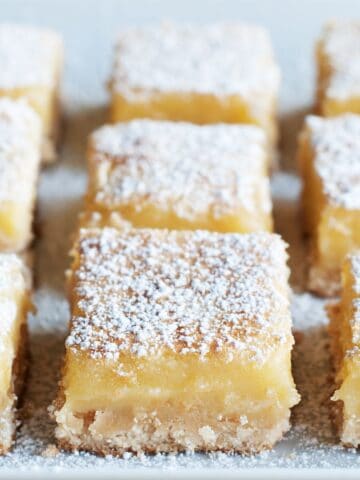 Healthy lemon bars with powdered sugar cut into squares on a tray